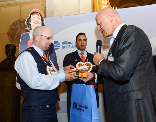Hier im Bild: Ulrich Homburg (Vorstand Personenverkehr, DB Mobility Logistics) überreicht einen Geschenk-Gutschein an Oliver Vitze.