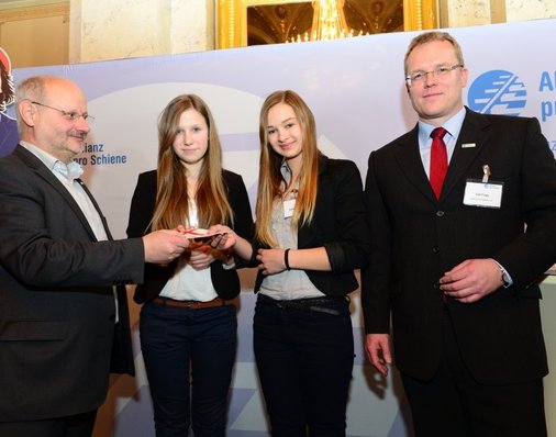 Jurymitglied Alexander Kirchner (EVG) überreicht Saskia und Annabell einen Reise-Gutschein für einen Städtetrip nach Köln - zu Peter Gitzen und dessen Familie.