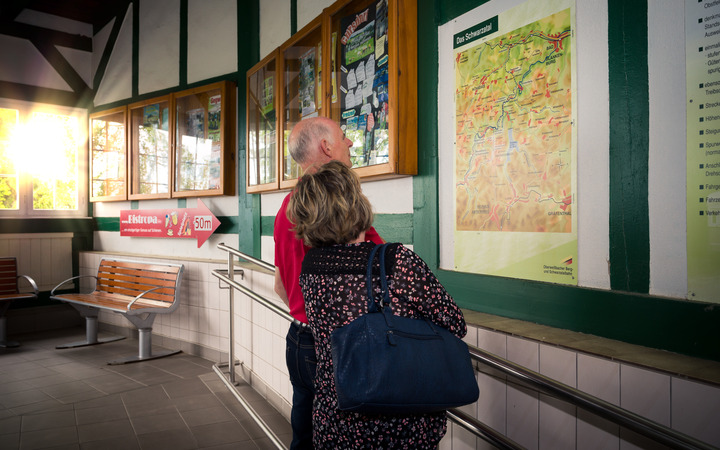 Touristen vor einer Karte im Bahnhofsgebäude