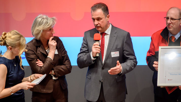 GDL-Chef Claus Weselsky würdigt Sondersieger Thomas Wiese (rechts), Zugbegleiter von National Express. Einsenderin Inge Schürmann und Moderatorin Janine Mehner hören zu.