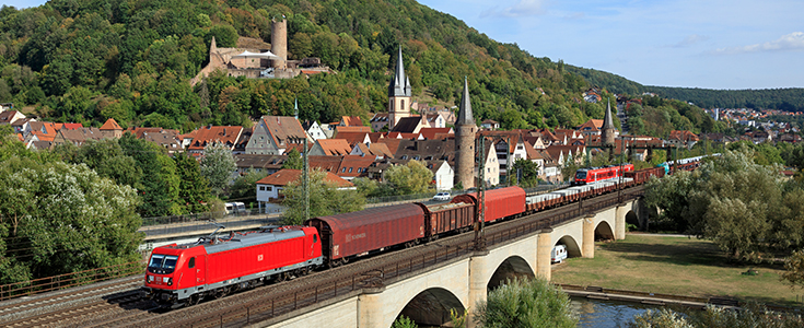 Eine Güterbahn vor idyllischer Kulisse.