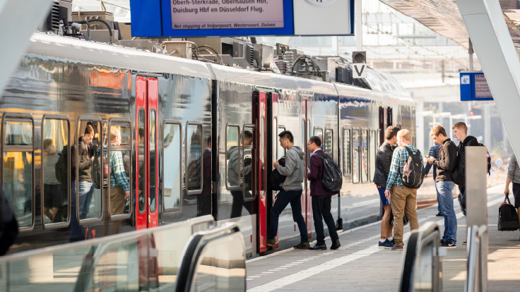 Reisende steigen in Düsseldorf in eine Bahn ein.