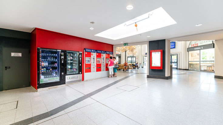 Ticketschalter und digitale Infostele im Bahnhof Coburg.